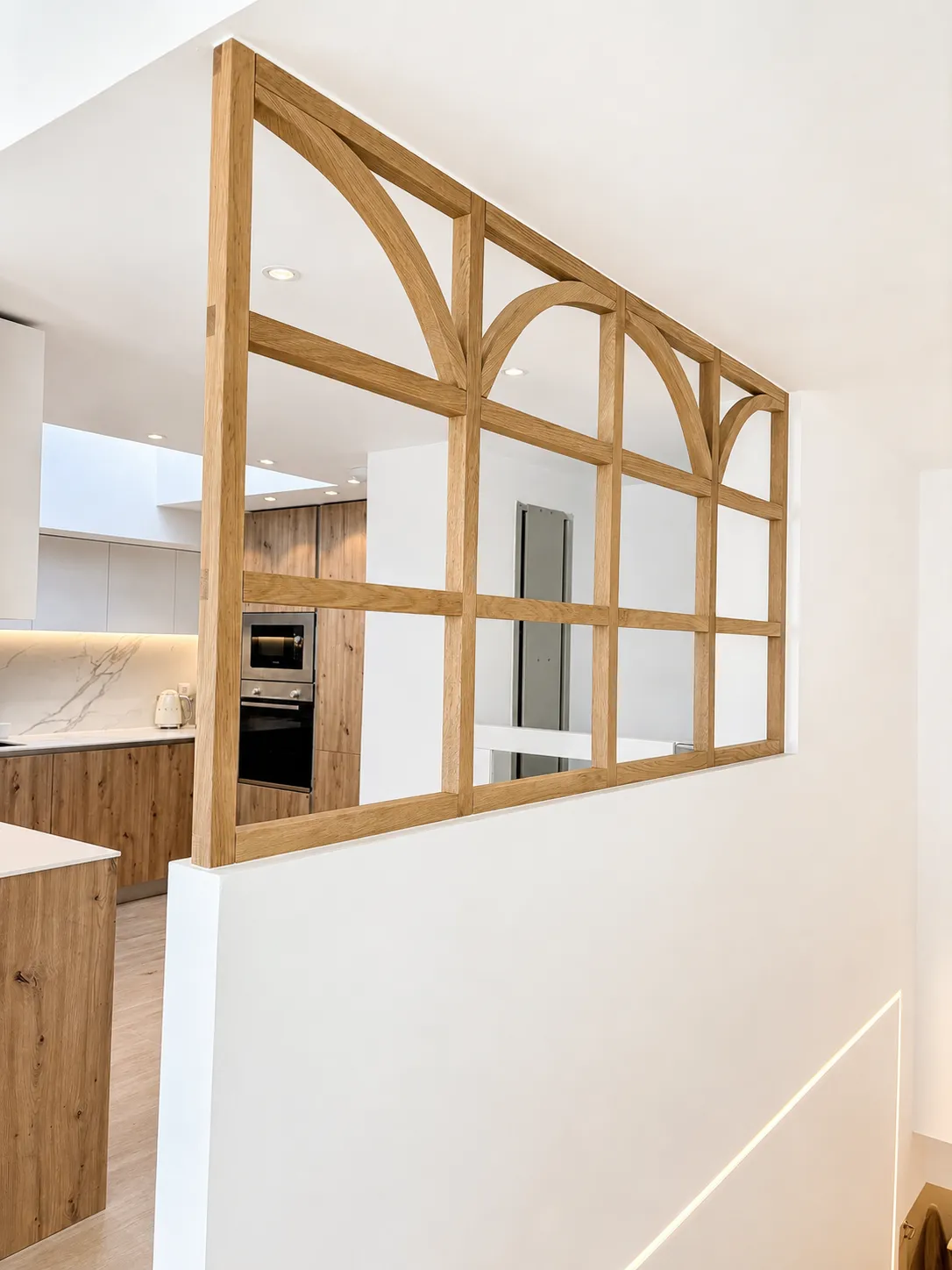 celosía de madera en arco entre la cocina y el pasillo