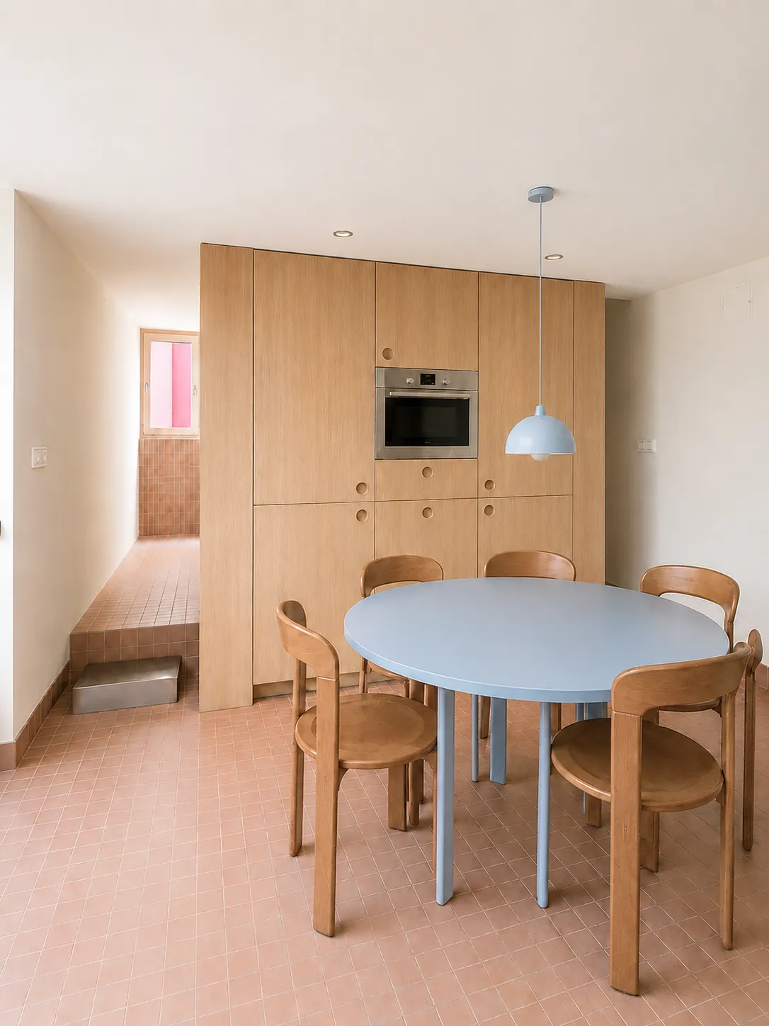 cocina-comedor con mesa ovalada y muebles de roble