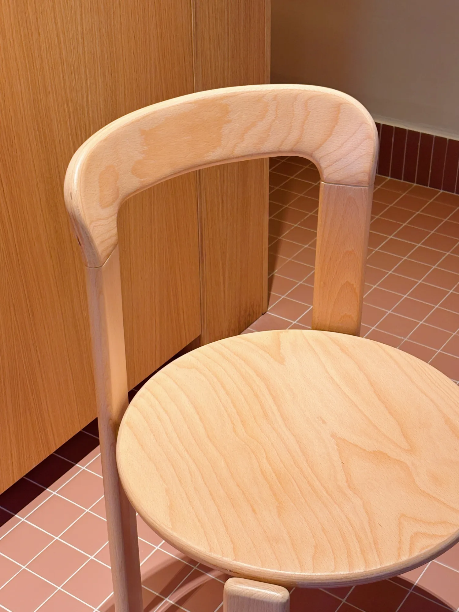silla de madera sobre baldosa rosa