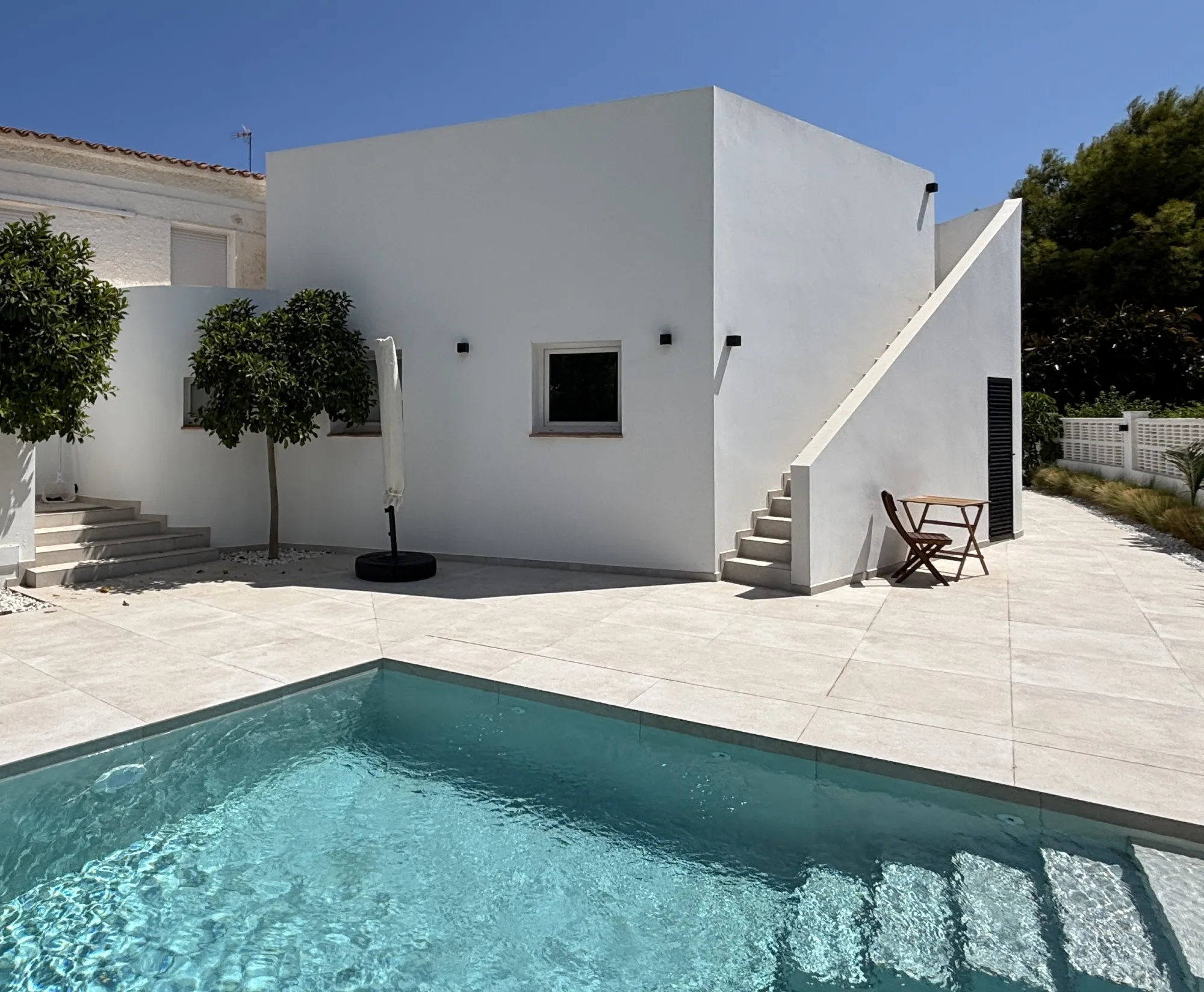 exterior con piscina, fachada blanca elevada